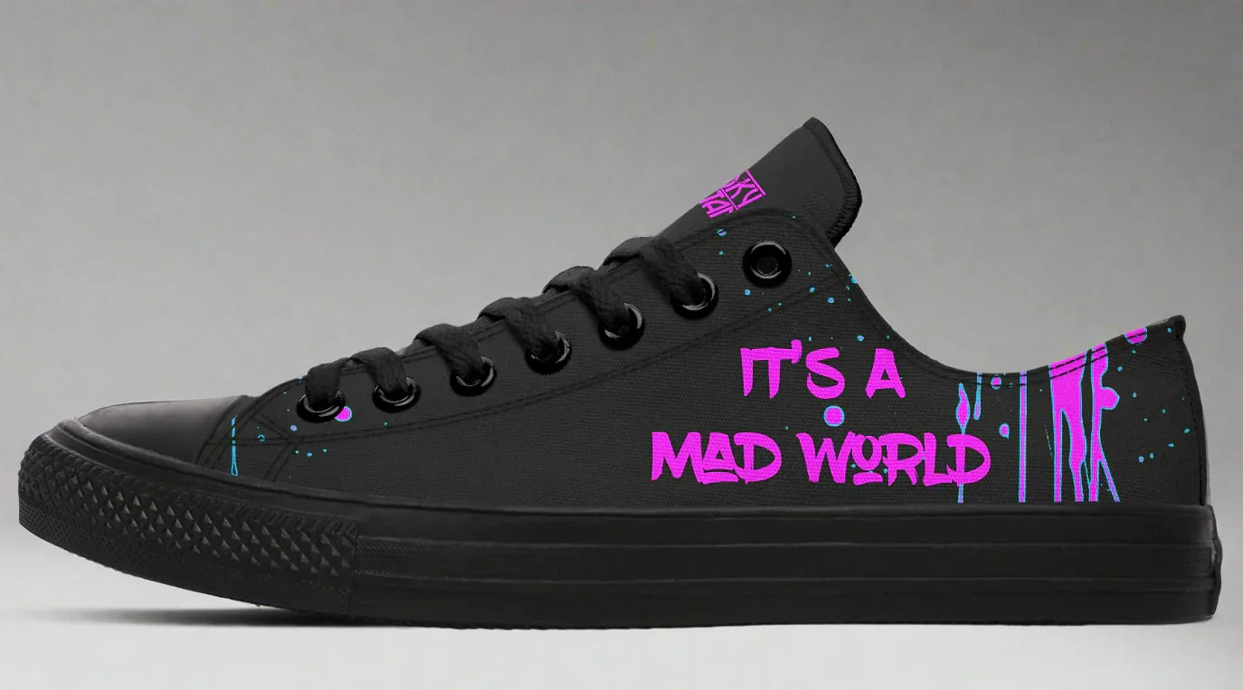 Black low-top sneakers featuring neon pink text reading “IT’S A MAD WORLD” on the outer side of the left shoe, set against a backdrop of chaotic pink splatter art. Matte black midsole, toe cap, and eyelets create a clean base that lets the pink design stand out. Cyber Cat design by Sky Titan Media, blending futuristic vibes with bold, music-infused streetwear energy.
