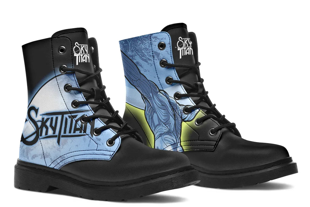Black lace-up boots featuring bold blue artwork of Atlas and glowing celestial elements — the Skybound design by Sky Titan Media. The left boot shows Atlas across both inner and outer sides, lifting the sky in comic-style detail, while the right boot features a glowing moon with a yellow stroke on the outer side and the Sky Titan logo on the inner panel. Black metal eyelets and soles frame the mythic scene. 