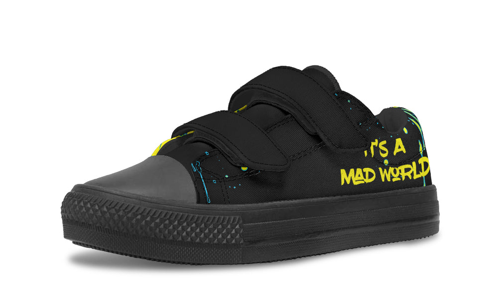 Kids’ black low-top sneakers featuring a vibrant neon cyberpunk-style cat illustration – Cyber Cat design by Sky Titan Media, built for young rebels with a love for futuristic flair and music-fueled streetwear.
Zoomed in, the left shoe makes its mark—“It’s A Mad World” jumps off the black canvas in a loud, neon yellow font. The black Velcro strap and toe box keep things grounded in style.