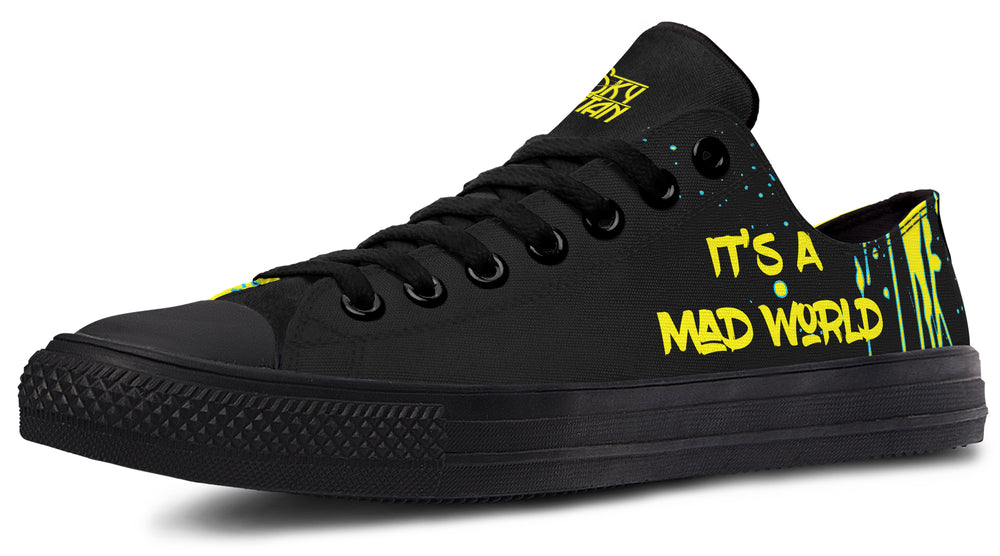 Black low-top sneakers featuring bold yellow text reading “IT’S A MAD WORLD” on the outer side of the left shoe. Surrounded by paint strokes and splashes in teal and yellow, the design evokes chaotic creativity on a deep black background. Cyber Cat design by Sky Titan Media, blending futuristic vibes with bold, music-infused streetwear energy.
