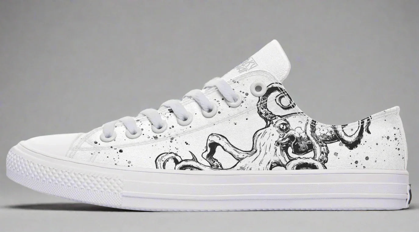 Side view of white low-top sneakers featuring Sky Titan Media’s “Ink Splatter Octopus” design — a surreal, hand-drawn octopus in black ink stretches across the outer panel, surrounded by chaotic splatter accents. The Sky Titan logo is subtly printed on the outer tongue, adding a branded detail that complements the shoe’s fusion of marine surrealism and indie streetwear aesthetic.