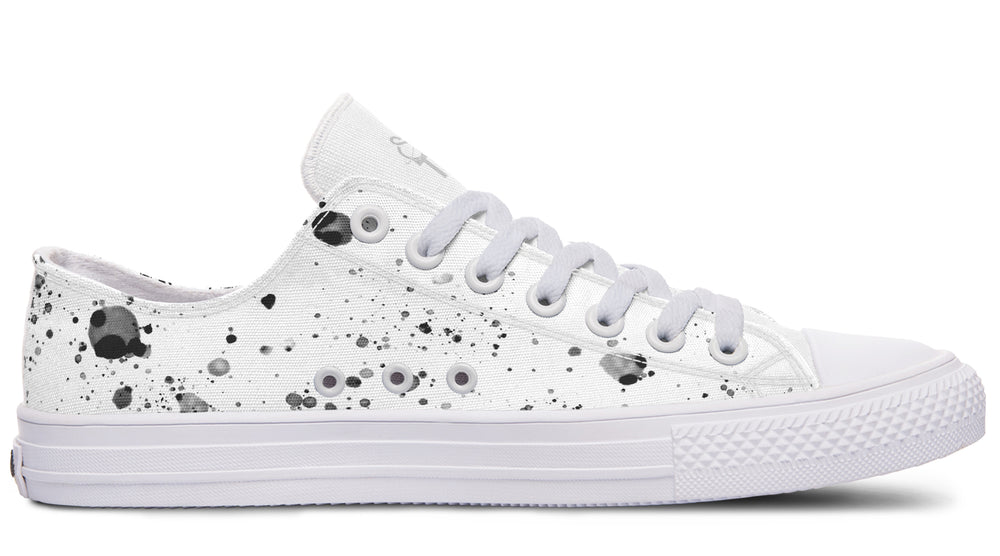 White low-top canvas sneakers featuring Sky Titan Media’s ‘Ink Drop’ design. Monochrome splatter patterns spread across the white canvas upper, paired with white laces, eyelets, and a rugged sole — clean chaos with a street art twist.