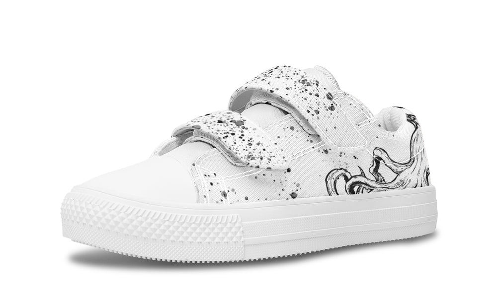 Side profile of the white-soled Octopus White Out Edition kids’ sneaker by Sky Titan Media, featuring hand-drawn black tentacle lines along the white canvas and a single bold velcro strap splashed with black ink. A stylish, kid-friendly silhouette that balances artistic expression with easy all-day wear.