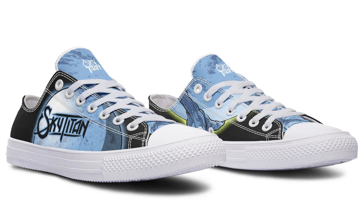 Black and white low-top sneakers featuring blue-toned artwork of Atlas holding up the sky — the Skybound design by Sky Titan Media. This variant reimagines the original with white accents on the toebox, laces, eyelets, and midsole, offering a bold contrast to the deep blacks and mythic blues. The inner side showcases a comic-style rendering of Atlas, while the outer side reveals a glowing moon above the Sky Titan logo.  Blending mythology-inspired visuals with streetwear rooted in independent music culture.