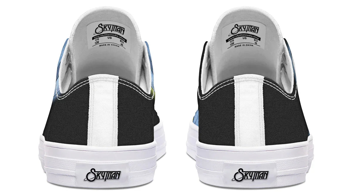 Back view of black and white low-top Skybound sneakers by Sky Titan Media, featuring stitched black canvas heel panels and reinforced soles. A bold white Sky Titan logo anchors the heel tab, while the inner labels echo the branding in sleek monochrome. This clean, high-contrast finish complements the mythic design and white-accented details throughout, blending mythology-inspired visuals with streetwear rooted in independent music culture.