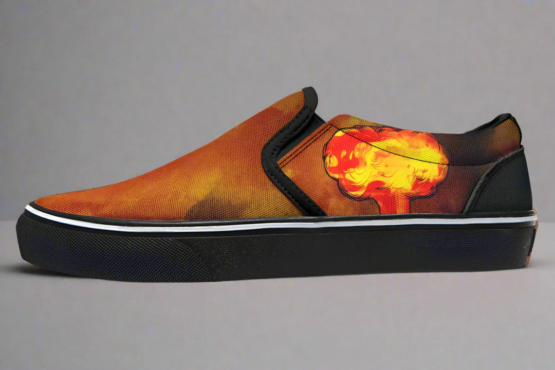 Black slip-on sneaker featuring a red-orange smoke explosion blast on the outer canvas of the left shoe, with no figure artwork. Framed in black trim and grounded by a clean black sole — Bomber Girl design by Sky Titan Media, merging vintage attitude with edgy, music-fueled streetwear style.