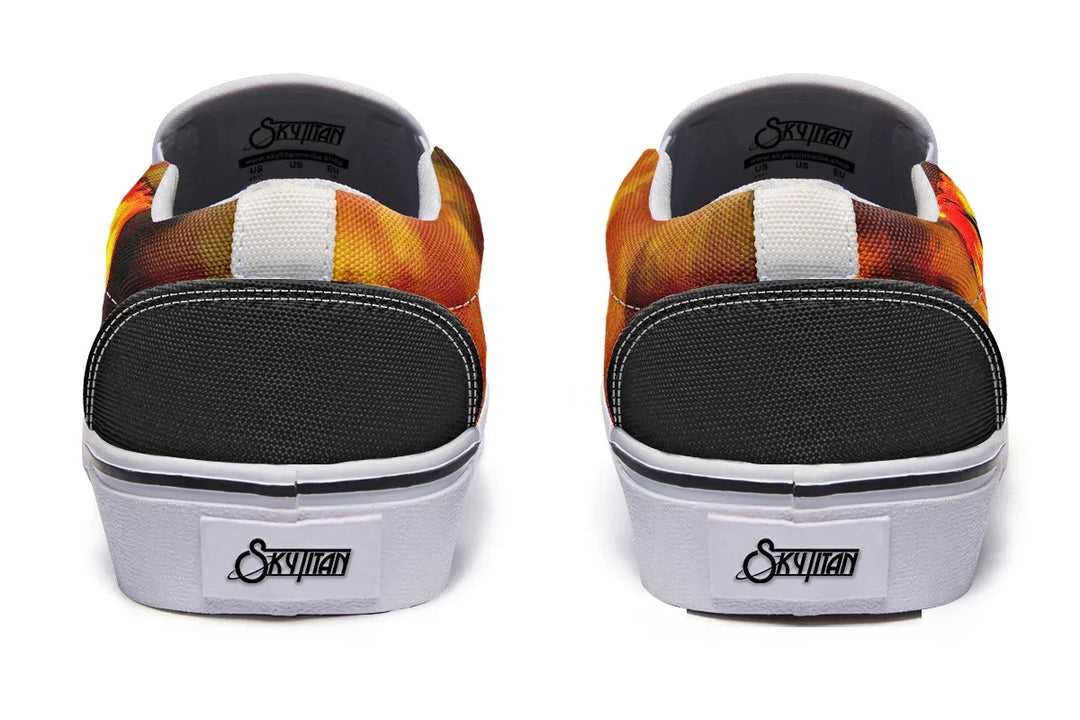 Black slip-on sneakers with reinforced black heels and bold white midsole and trim. The orange smoke wraps around both shoes, creating continuity across the rear view. — Bomber Girl design by Sky Titan Media, merging vintage attitude with edgy, music-fueled streetwear style.