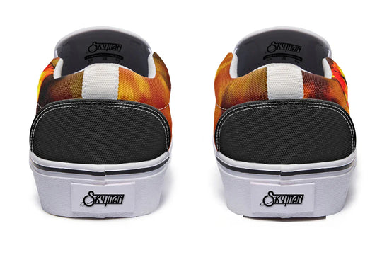 Black slip-on sneakers with reinforced black heels and bold white midsole and trim. The orange smoke wraps around both shoes, creating continuity across the rear view. — Bomber Girl design by Sky Titan Media, merging vintage attitude with edgy, music-fueled streetwear style.