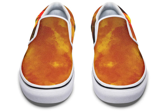 Black slip-on sneakers featuring a vivid orange-red smoke gradient flowing across the canvas uppers of both shoes. White binding and bright white inner panels create a bold contrast, while the black elastic gores add structure. No visible illustration from this angle, just color, contrast, and clean silhouette. — Bomber Girl design by Sky Titan Media, merging vintage attitude with edgy, music-fueled streetwear style.