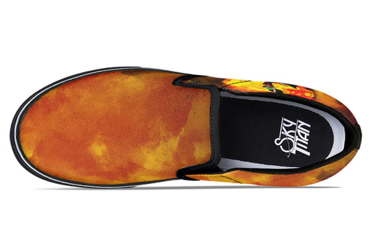 Black slip-on sneakers featuring a vivid orange-red smoke gradient flowing across the canvas uppers of both shoes. The black elastic gores and piping frame the design, while the Sky Titan logo is visible on the insole. No visible illustration from this angle, just bold color and clean silhouette. — Bomber Girl design by Sky Titan Media, merging vintage attitude with edgy, music-fueled streetwear style.