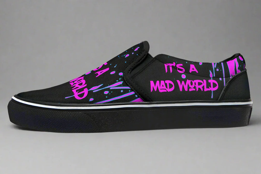 Black slip-on sneakers with bold cyber cat punk artwork and graffiti text – Cyber Cat Pink Edition by Sky Titan Media, blending fierce futuristic style with bold, music-driven streetwear attitude.
This left shoe is a visual protest—its bright pink graffiti text reads “IT’S A MAD WORLD” twice: once across the toe and again along the outer panel. Urban, direct, and unfiltered.