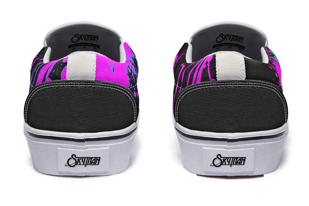 Black slip-on sneakers featuring asymmetrical cyber cat punk artwork and graffiti statements with white detailing — the Cyber Cat Pink Edition by Sky Titan Media, fusing futuristic street rebellion with bold, music-charged expression.
From the back, a grounded minimalism emerges: black heel panels stitched cleanly into a white sole wrap. A quiet foundation to a bold visual narrative.