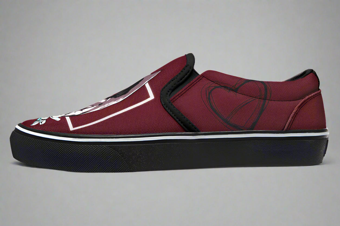 Side profile of the red slip-on sneaker showing heart line art near the heel. The clean black outsole and red canvas upper emphasize the minimalist yet expressive style of the “July” design by Sky Titan Media.