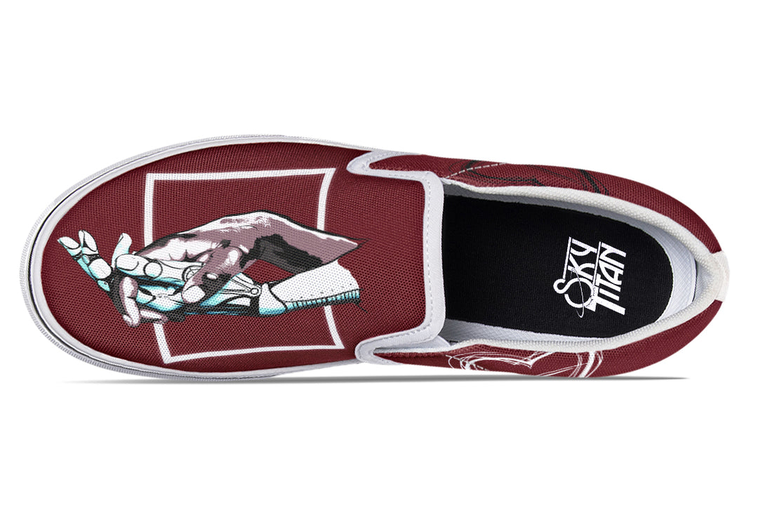 Top-down view of a single red slip-on sneaker from Sky Titan Media’s “July” design. The white sole frames the mechanical hands illustration,and white elastic panels and detailed stitching refine the visual balance.
