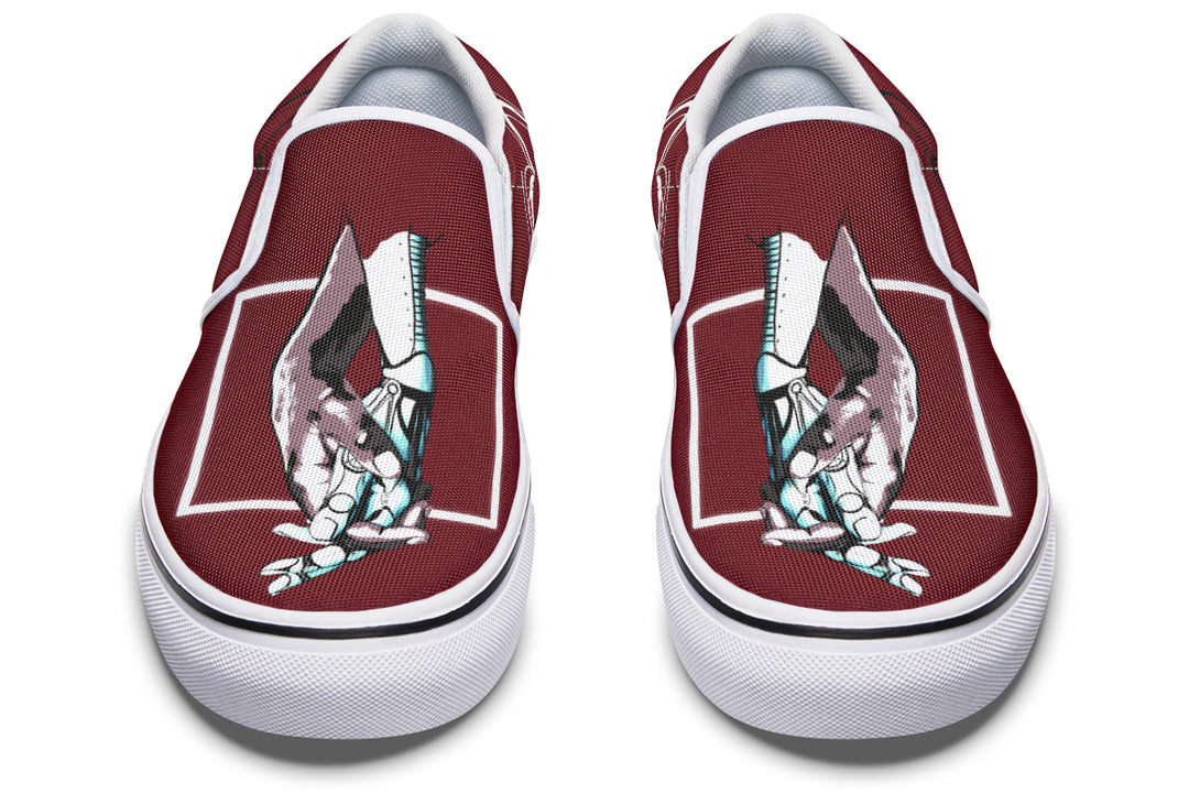 Frontal view of the red “July” slip-ons by Sky Titan Media, now featuring bright white soles and visible contrast stitching. The central artwork—robotic hands reaching across dimensions—remains a strong symbol of connection and narrative depth.