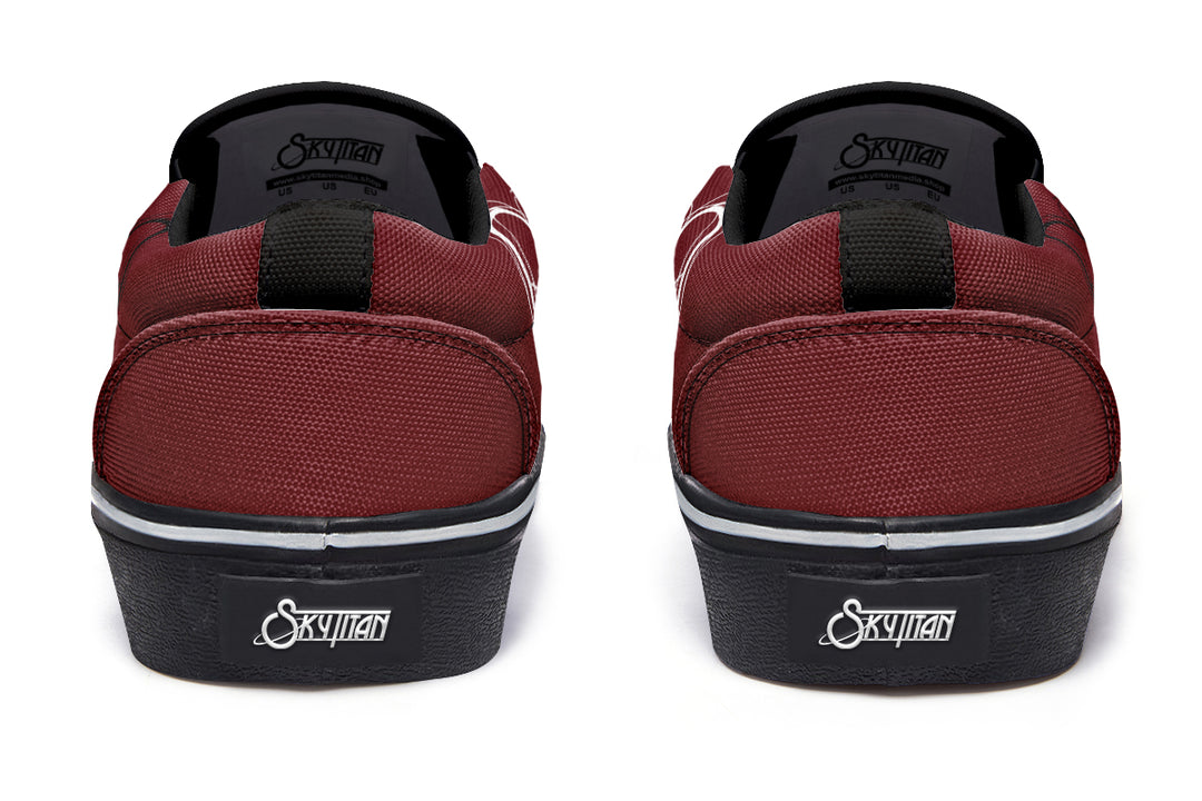 Back view of the red “July” slip-on sneakers. Black pull tabs rise from the heel, with the Sky Titan Media logo placed on a stitched black heel badge for distinct branding. Canvas texture and red paneling frame the design.