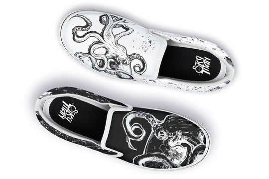 Flat lay of mismatched slip-on sneakers by Sky Titan Media – one black, one white, each with inverse octopus art and paired with bright white soles for balance, form, and flow in this Dual Canvas Edition.