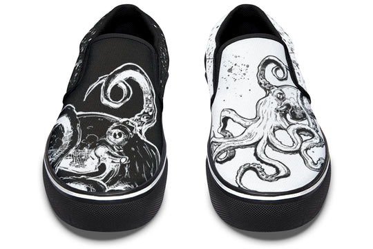 Front-facing view of mismatched Sky Titan Media slip-ons – a high-contrast pair featuring octopus tentacles and paint splashes across black and white canvas, designed to stand out.
