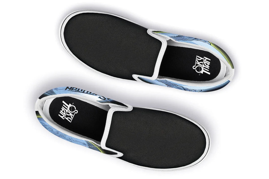 Top-down view of Skybound slip-ons in the white-detail variant. White elastic gores and midsoles contrast with the cosmic blue and yellow artwork flaring from the canvas sides. Sky Titan logos appear on both insoles. — Skybound design by Sky Titan Media, blending mythology-inspired visuals with streetwear rooted in independent music culture.