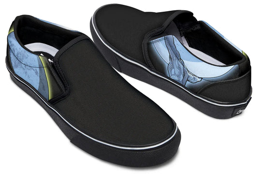 Black slip-on sneakers featuring Sky Titan Media’s Skybound design. The left shoe displays a blue-toned Atlas across both outer and inner sides, lifting the sky toward the moon, while the right shoe features a glowing moon with a yellow halo stroke on the outer side, and a Sky Titan logo with the moon on the inner side. A visual story of burden and balance told across both feet — Skybound design by Sky Titan Media, blending mythology-inspired visuals with streetwear rooted in independent music culture.